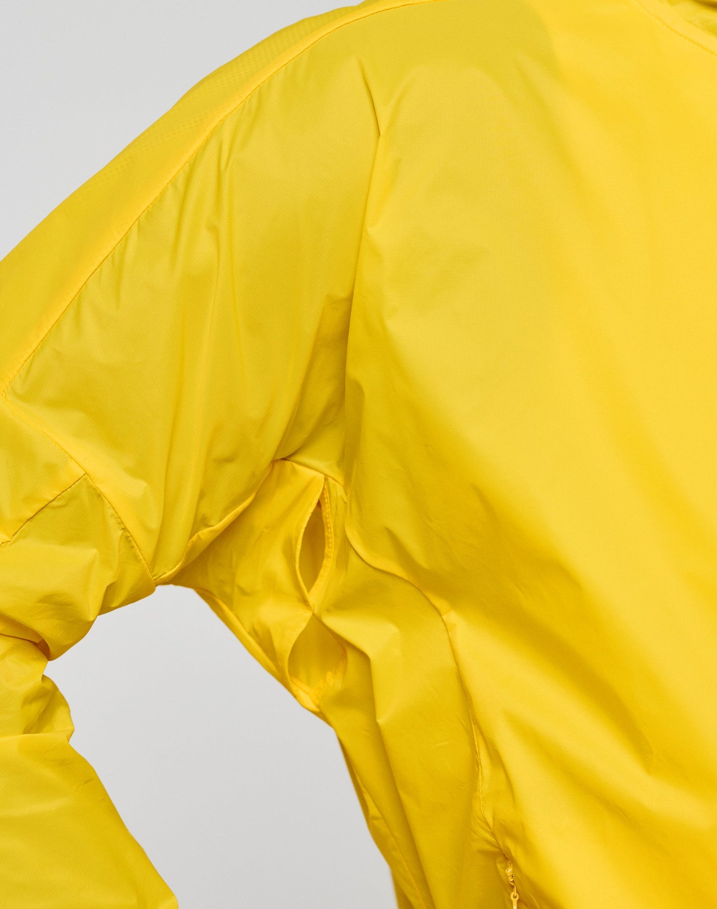 Close-up of the LIVE FAST DIE YOUNG Live Fast Performance Running Jacket in bright yellow, Regular Fit, highlighting the underarm vent; set against a plain light background.
