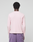 A person with short curly hair, seen from behind, wears a light pink LIVE FAST DIE YOUNG Basic Waffle Longsleeve with Ripp-Bündchen and purple shorts with a back pocket, made of soft cotton, against a plain light gray background.