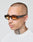 A man with a shaved head and tattooed neck wears LFDY x Chimi Shades 09 by LIVE FAST DIE YOUNG, featuring amber-tinted rectangular frames, paired with a white shirt against a plain light background.