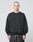 A person with a buzz cut is wearing the LIVE FAST DIE YOUNG Basic Blank Sweater, an Oversize Fit black sweatshirt made from soft Baumwolle and Polyester, paired with black shorts, standing against a plain light gray background.