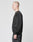 A person with a shaved head stands in profile against a plain light gray background, wearing an oversize fit Basic Blank Sweater and black pants by LIVE FAST DIE YOUNG, both crafted from soft Baumwolle.