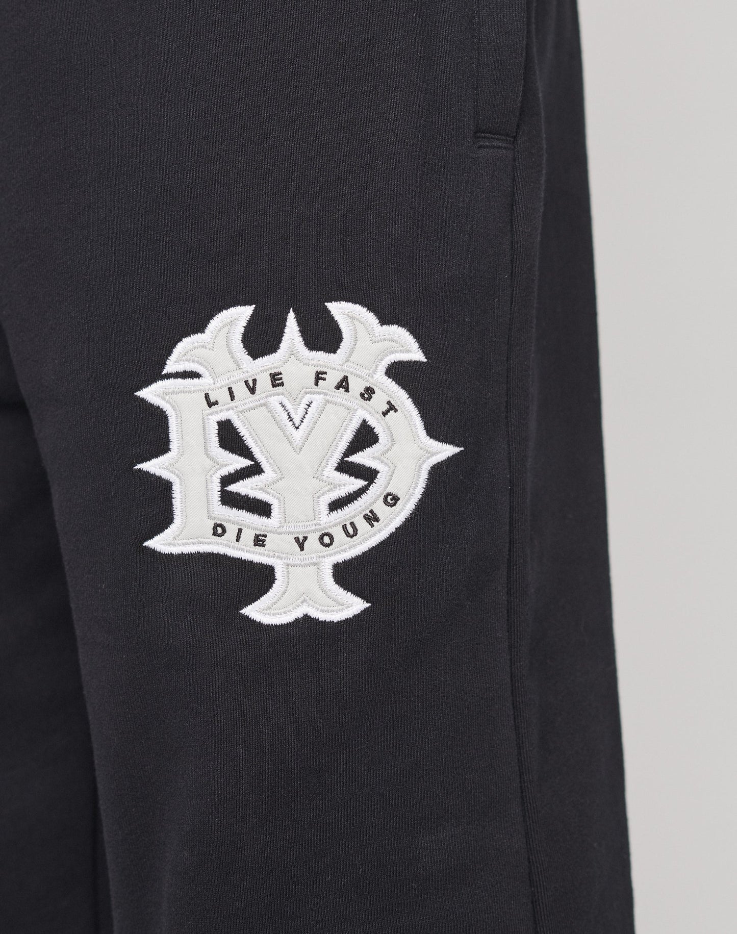 Die DY Loose Jogger von LIVE FAST DIE YOUNG ist eine schwarze Baumwollhose im Loose Fit mit Elastikbund, verziert mit einem weißen Patch samt Markenemblem an der Seite.