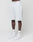 A person wears LIVE FAST DIE YOUNG Basic Shorts in regular fit with elastic waistband and logo print, paired with white LFDY socks and white Nike sneakers, standing against a plain white background.