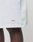 Close-up of a person wearing LIVE FAST DIE YOUNG Basic Shorts in light gray with a subtle gold logo print near the hem. These regular-fit shorts are shown against a minimal, neutral background.