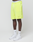 A person wears neon yellow Basic Shorts by LIVE FAST DIE YOUNG with elastischer Bund, white crew socks with “LEDFY” logo print, and white Nike sneakers. Only their lower half is visible, standing against a plain white background.