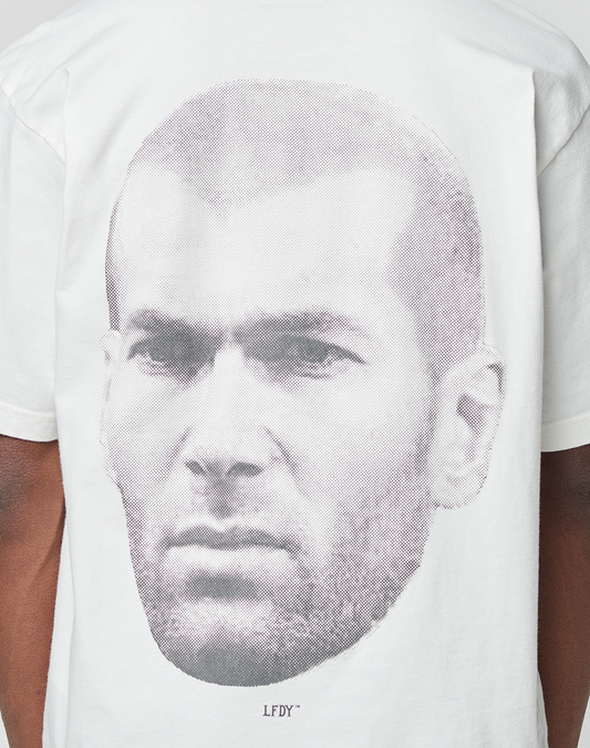 Wearing the LFDY Zizou Tee by LIVE FAST DIE YOUNG: an oversize white 100% Baumwolle shirt with a bold grayscale man's face backprint, small LFDY text beneath, and subtle front and backprint details.
