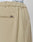Close-up of beige Wide Casual Pants by LIVE FAST DIE YOUNG, featuring a back pocket, side seam, and a small metallic tag. The waistband of white underwear branded LIVE FAST is visible above the pants.