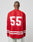 A person with a shaved head wears the LIVE FAST DIE YOUNG LFDY Hockey Jersey—an oversized red polyester top with white stripes and bold “55” print on the back—paired with light-colored jeans, facing away from the camera.