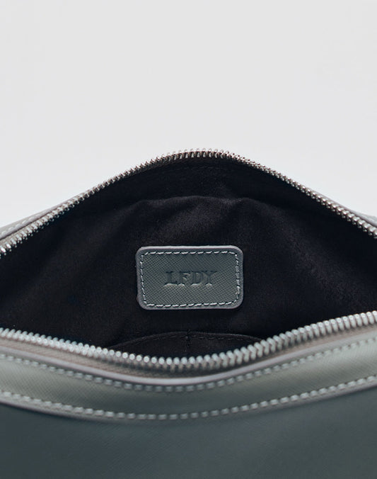 A close-up of an open gray Airliner Bag by LIVE FAST DIE YOUNG, one size, reveals a black interior and a stitched leather label embossed with the LFDY logo.