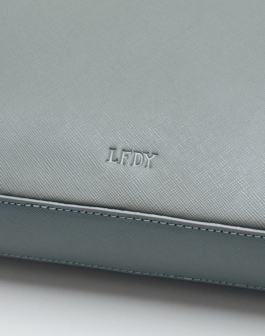 A close-up of the Airliner Bag by LIVE FAST DIE YOUNG in light gray textured leather, featuring the embossed LFDY logo at the center.