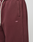 Close-up of a person wearing the LIVE FAST DIE YOUNG Basic Wide Jogger in maroon with wide fit, side pockets, white drawstrings, and small white LFDY™ logo embroidered on the left thigh.