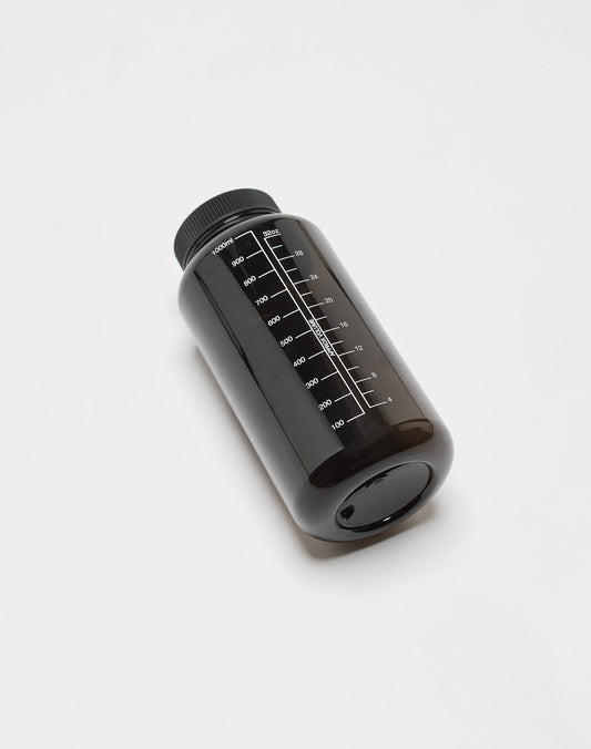 The LIVE FAST DIE YOUNG Live Fast Performance Gym Bottle (LF2501-17113) is a black 100% Tritan, BPA-free bottle with a black screw cap and milliliter markings from 100ml to 1000ml, lying on its side on a white surface.