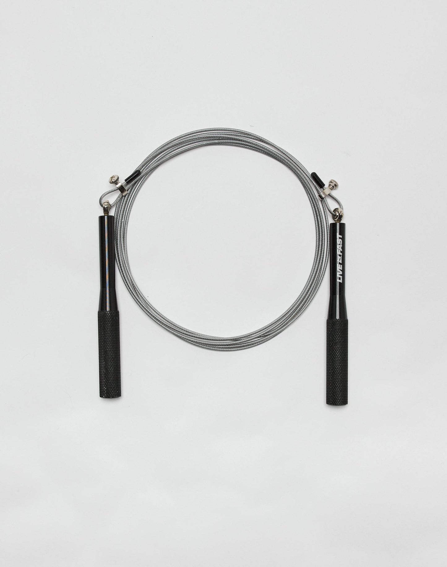 The Live Fast Performance Jump Rope by LIVE FAST DIE YOUNG, featuring black handles and a thin silver cable, is coiled neatly on a plain white background.