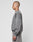 A person with a shaved head stands in profile, wearing a faded gray LIVE FAST DIE YOUNG Basic Chest Sweater made from soft Baumwolle, paired with matching sweatpants, against a plain light background.