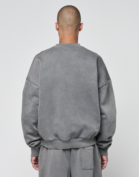A person with a shaved head stands with their back to the camera, wearing a grey Basic Chest Sweater from LIVE FAST DIE YOUNG and matching sweatpants against a plain light background.