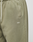 Close-up of the LIVE FAST DIE YOUNG Basic Wide Jogger in olive green, featuring a wide fit, elastic waistband, cream drawstring, slanted pocket, and a small white LFDY logo embroidered on the upper thigh.