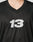 Close-up of a person wearing the LIVE FAST DIE YOUNG Live Fast Jersey in black, featuring an oversized fit and a white reflective number 13 print on the front. Only the neck and upper chest are visible; head and lower body not shown.