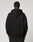 A person faces away from the camera, wearing the LIVE FAST DIE YOUNG Live Fast Plain Hooded black oversize hoodie and matching soft Baumwolle pants, set against a plain light background.