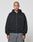 A person with a shaved head wears the LIVE FAST DIE YOUNG Basic 510 Hooded Zip in Oversize Fit and gray jeans, standing facing forward against a plain light gray background.