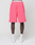 A person wears LIVE FAST DIE YOUNG Basic Shorts in bright pink with a regular fit, elastic waistband, side pocket, and visible logo print, paired with white socks and sneakers. Photo is cropped above the waist on a plain light background.