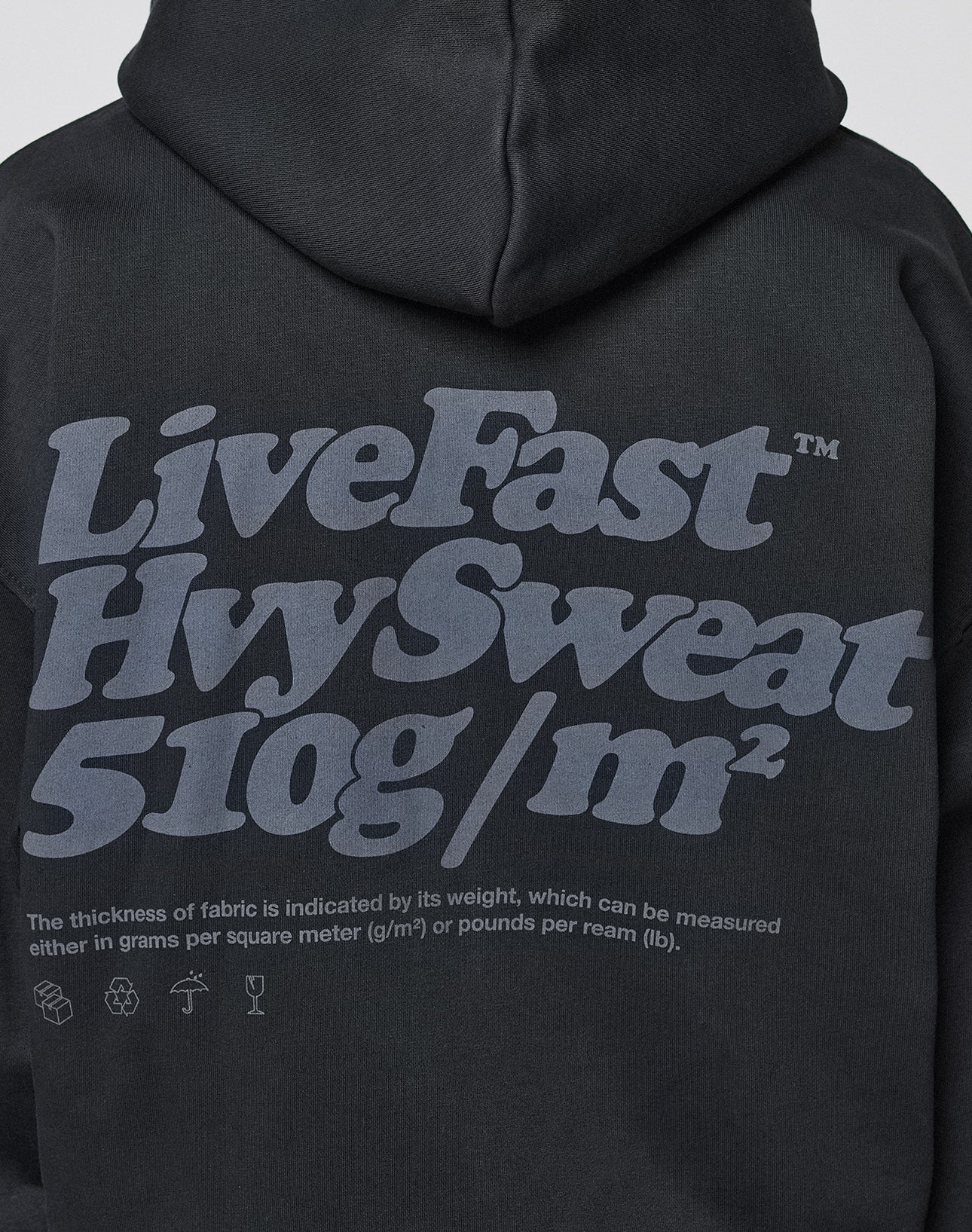 The LIVE FAST DIE YOUNG Basic 510 Hooded Zip is a black oversize-fit hoodie with front and large gray back print: “LiveFast HvySweat 510g/m²” plus fabric thickness info, offering a bold look.