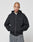 A person with a shaved head wears the LIVE FAST DIE YOUNG Basic 510 Hooded Zip with front and back print and oversize fit, paired with baggy gray jeans, standing hands-in-pockets against a plain light gray background.