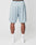 A person faces away wearing LIVE FAST DIE YOUNG LFDY Loyal Shorts in light blue mesh polyester with an elastic waistband and a small right back pocket, paired with white crew socks and sneakers, against a plain white background.