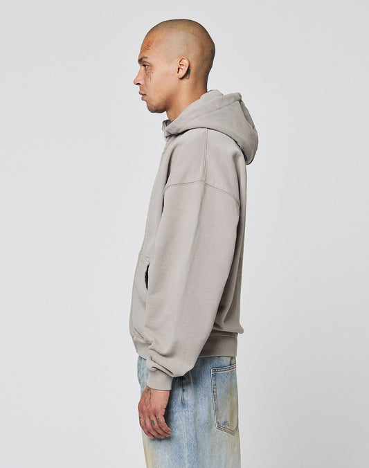 A person with a shaved head stands in profile against a plain background, wearing the LIVE FAST DIE YOUNG Basic 510 Hooded Zip hoodie in light gray and faded blue jeans in vintage wash.