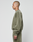 A person with a shaved head stands in profile, wearing an olive green LIVE FAST DIE YOUNG Basic Chest Sweater and matching sweatpants in oversize fit, against a plain white background.