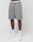 A person models LIVE FAST DIE YOUNG Basic Shorts in grey with an elastic waistband, paired with LFT logo white socks and white sneakers, standing against a plain white background. Only their lower torso and legs are visible.