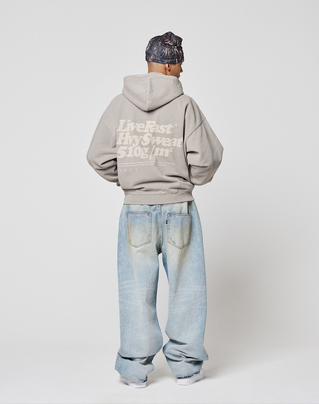 A light gray LIVE FAST DIE YOUNG Basic 510 Hooded Zip with front and back prints. Bold white "LiveFast HvySweat 510g/m²" text on the back, smaller care details, and a cool vintage wash complete the look.