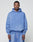 A man faces forward in a matching light blue LIVE FAST DIE YOUNG Basic Evidence Hooded sweatshirt and sweatpants with an oversize fit, front pocket, and small chest text, set against a plain background to highlight the relaxed style.