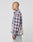 A person with a shaved head wears the LIVE FAST DIE YOUNG Vintage Flannel in blue, white, and pink plaid and light-wash Oversize Fit jeans, posing in profile against a plain white background.