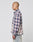 A person with a shaved head wears the LIVE FAST DIE YOUNG Vintage Flannel in blue, white, and pink plaid and light-wash Oversize Fit jeans, posing in profile against a plain white background.