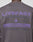 A person wearing the LFDY Network Sweater by LIVE FAST DIE YOUNG—an oversize dark gray sweatshirt with bold purple "LIVEFAST DEALERSHIP" back print, plus details like a website, phone number, and various country names.