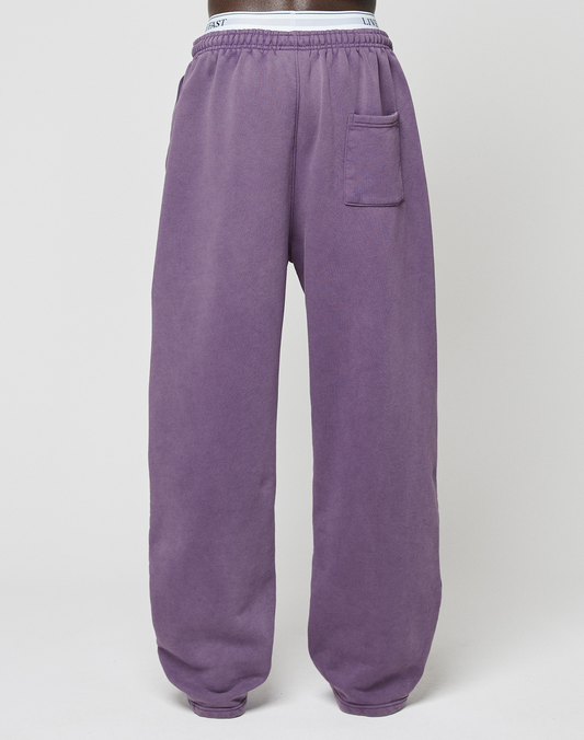 The LIVE FAST DIE YOUNG Basic Wide Jogger sweatpants feature a purple color, elastic waistband, single right patch pocket, and relaxed wide-leg fit. Displayed on a plain white background.