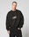 A person with short hair wears the LIVE FAST DIE YOUNG Fuck Die Young Sweater—an oversize black polyester sweatshirt with LIVE FAST VULGAR DIE YOUNG in white—paired with black pants, standing against a plain, light background.