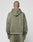 A person with a shaved head models the LIVE FAST DIE YOUNG Basic +49 Hooded sweatshirt and matching pants in olive green, featuring an oversize fit and subtle faded look, standing with their back to the camera against a light gray background.
