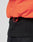 Close-up of a person wearing the Live Fast Cropped Vest by LIVE FAST DIE YOUNG, a bright orange puffer with a red drawstring at the hem, styled over a black ribbed sweater and dark pants. Regular fit with practical Druckknöpfe for easy fastening.