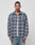 A man stands facing forward in the LIVE FAST DIE YOUNG Loose Flannel Shirt, featuring a gray and pink plaid vintage wash, layered over a white tee and blue jeans against a plain light background.