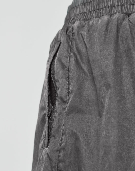 Close-up of LIVE FAST DIE YOUNG Live Fast Swimshorts in gray crinkled polyamide, Regular Fit, with elastic waistband and a side pocket with black zipper. Shown against a plain light background.