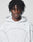 A young person with twisted black hair wears the LFDY Active Fleece Hooded Zip by LIVE FAST DIE YOUNG—a light gray, oversized zip-up hoodie with thin curved seams and a minimal logo on the shoulders, set against a plain light background.