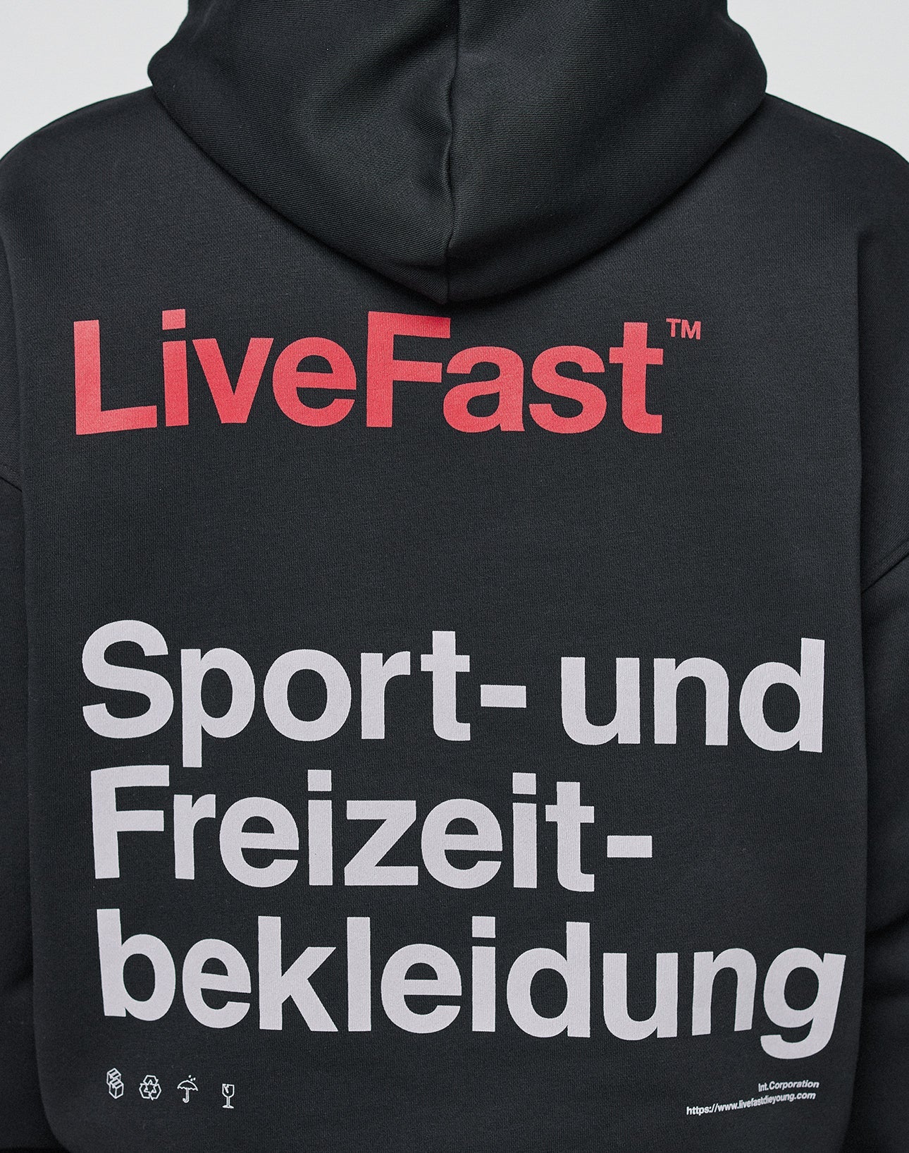 The back of the Basic Trademark Hooded by LIVE FAST DIE YOUNG features bold red LiveFast, large white Sport- und Freizeitbekleidung, front and back prints, small white icons, website info, oversize fit, and is made from 65% Baumwolle.