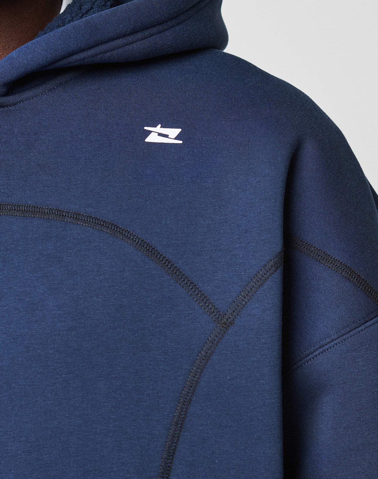 Close-up of a person wearing the LIVE FAST DIE YOUNG LFDY Active Fleece Hooded Zip in navy blue with black seam details and a small white logo print on the chest near the shoulder. The hood is partially visible.