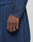 A close-up of a hand and forearm wearing the LIVE FAST DIE YOUNG LFDY Active Fleece Hooded Zip in navy blue, featuring an oversize fit and black stitching. Matching pants are shown against a neutral, blurred background.