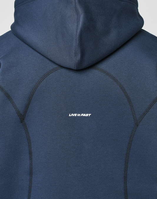 A close-up of the back of the navy LFDY Active Fleece Hooded Zip by LIVE FAST DIE YOUNG, featuring prominent stitching and a small white LIVE FAST logo print at the center.