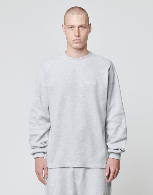 A person with a shaved head wears the LIVE FAST DIE YOUNG Basic Script Waffle Longsleeve in light gray with matching pants, standing against a plain light gray background and facing the camera with a neutral expression.