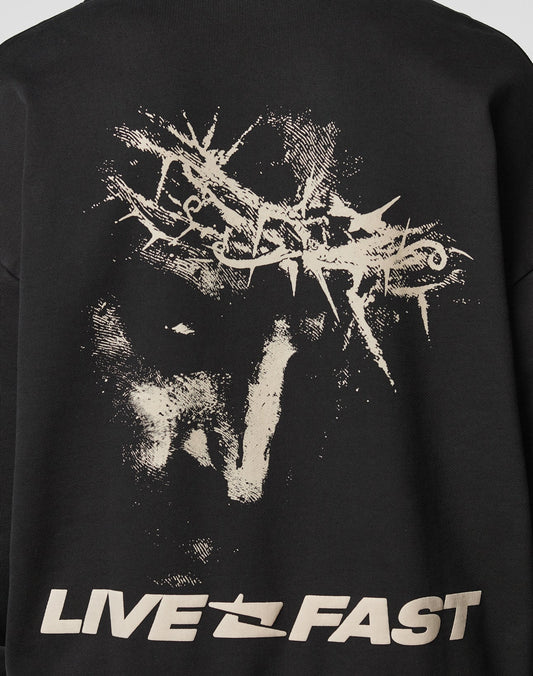 The LFDY Savior Hooded by LIVE FAST DIE YOUNG is a black oversized hoodie with a distressed abstract thorn print above a ghostly face and LIVE FAST in bold off-white letters. Made from 100% Baumwolle for comfort.