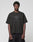 A person stands against a light gray background, wearing the Live Fast LF Tee by LIVE FAST DIE YOUNG—an oversize-fit black T-shirt with a "LIVEFAST" front print, made from 100% Baumwolle—and paired with black shorts.