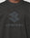 Close-up of a person wearing the Live Fast LF Tee by LIVE FAST DIE YOUNG, a black oversized shirt with a bold stylized frontprint logo and LIVEFAST in large capitals on the chest, crafted from 100% Baumwolle for ultimate comfort.